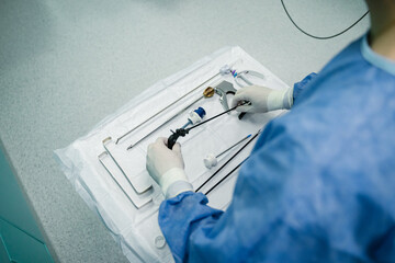 A skilled medical professional precisely prepares essential surgical instruments in a controlled operating room setting.