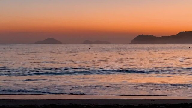 Final de tarde, ap&oacute;s o p&ocirc;r do sol, com o c&eacute;u limpo e o mar quebrando suave na areia. No horizonte, duas ilhas bastante conhecidas do Litoral Norte: Ilha das Couves e As Ilhas.