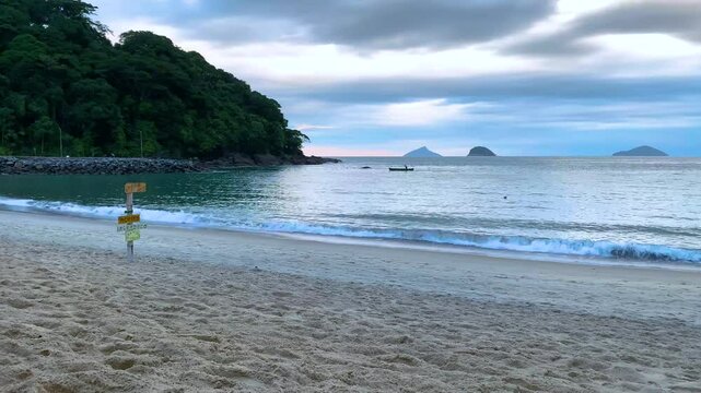 Fim de tarde e um pescador rema com sua canoa de volta pra casa, saindo do mar e entrando no rio. Ao fundo, tr&ecirc;s ilhas do Litoral Norte: Ilha Mont&atilde;o de Trigo, Ilha dos Gatos, Ilha das Couves.