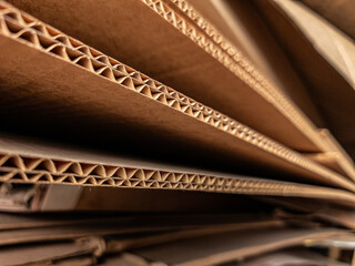 Close-up view of stacked corrugated cardboard layers, showcasing the intricate wave structure and...