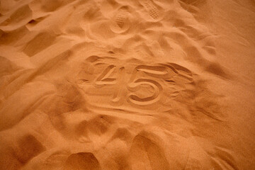 Dune 45 written in the sand at the summit of dune 45, a popular sand dune in the Namib desert near Sesriem and Sossuvlei.