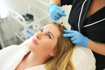 dermatologist cosmetologist performs a mesotherapy procedure and injects an injection into the...