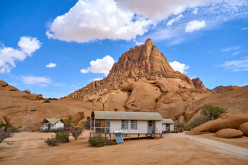 View looking up at the peak of Spitzkoppe in the desert of western Namibia with clouds up above