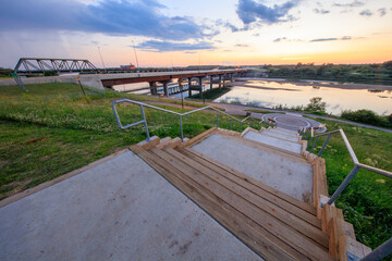 A bridge over a river with a beautiful sunset in the background