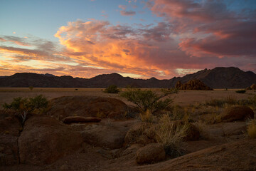 Amazing sunset in the Namibian desert near Sesriem with magnificent clouds and mountains in the background .
