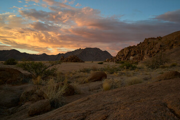 Amazing sunset in the Namibian desert near Sesriem with magnificent clouds and mountains in the background .