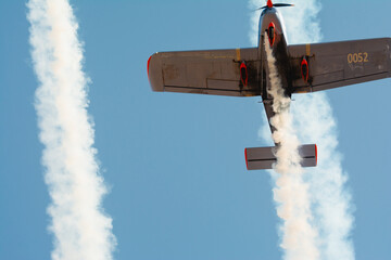 A small private plane against the sky. The single-engine plane performs aerobatics.