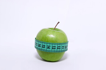 Green apple with measuring tape. Healthy eating and weight loss concept.
