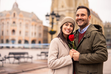 Mid adult Caucasian male surprises his partner with a rose on International Women's Day.