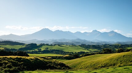 Fototapeta premium Picturesque mountain range with rolling green hills. Lush landscape under a clear sky.