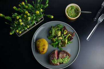 Medium rare beef steak with homemade Argentian style chimichurri, fondant potato and avocado salad