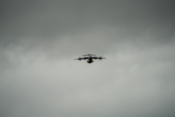 transport plane flying away from a low-level cargo parachute drop exercise