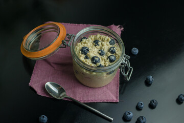 Bircher muesli - overnight oats - with blueberries in the glass jar, top view