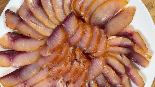 Sliced different cold smoked freshwater fish on plate, top view