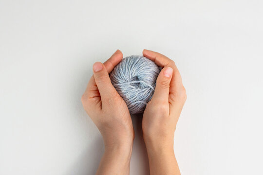 Hands holding ball of wool yarn on light background, copy space
