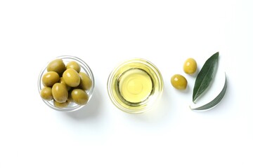 Bowl of fresh olive oil and olives with leaves on white background