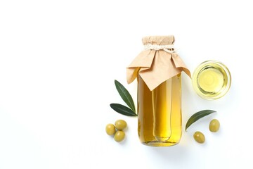 Bottle of fresh olive oil and olives with leaves on white background