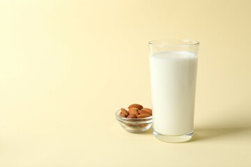 Glass of almond milk on color background