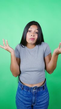 Frustrated mexican woman makes doubtful gestures and waves her hands asking why