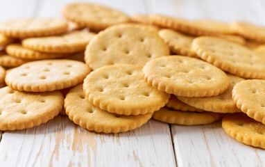 Heap of salted crackers round shape on a white table, selective focus.