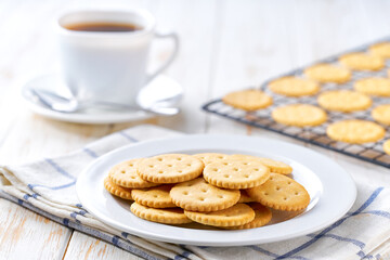 Salted crackers round shapes and coffee on a light kitchen table, selective focus.