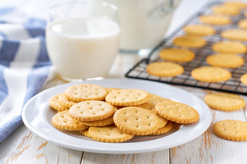 Wheat crackers round shape and a jug of fresh milk on a light kitchen table, healthy breakfast.