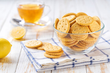 Wheat round crackers and tea on a white table, selective focus.