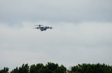 ZM401 RAF Royal Air Force Airbus C.1 A400M Atlas military transport plane in flight, on approach to a low-level cargo parachute drop exercise, light cloud sky