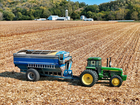 Fulton, Illinois, October 10, 2024, Kinze 840 Grain cart being pulled by a John Deere 4955 tractor with the farm scene in the background