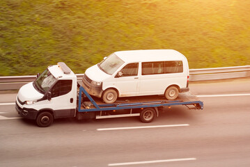 Tow Truck Hauling On Flatbed Passenger Van for Reliable Roadside Assistance and Vehicle Recovery
