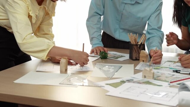 A video of architect use measurement tools and pencil to measure blueprint. Architect design house construction on a table at studio, with architectural plan scattered around. Focus hand. Delineation.
