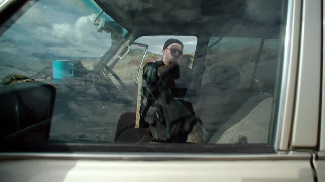 Handsome man load picnic items from the car with inspiration. weekend getaway. adventure and leisure time concept.