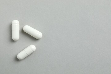 White capsules on a gray background