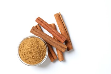 Cinnamon sticks and cinnamon powder in a plate on a white background