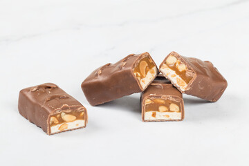 Candy bar. Nougat, caramel with peanuts, in chocolate. Close-up