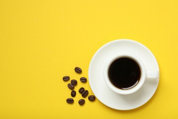 Cup of coffee and coffee beans on wooden background