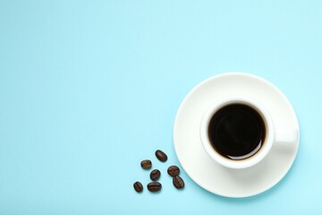 Cup of coffee and coffee beans on wooden background