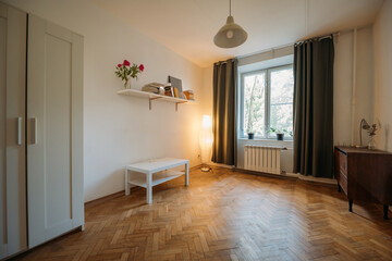 The interior of the apartment. A bright room with a minimum of furniture. Housewarming. The apartment is for rent.