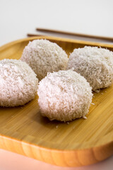 Japanese dessert mochi with red bean filling and coconut flakes. chopsticks.  food concept.