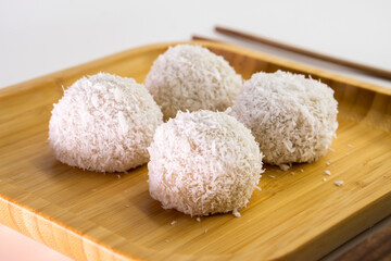 Japanese dessert mochi with red bean filling and coconut flakes. chopsticks.  food concept.