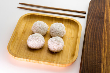 Japanese dessert mochi with red bean filling and coconut flakes. chopsticks.  food concept.