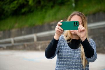 A woman takes photos with her mobile phone