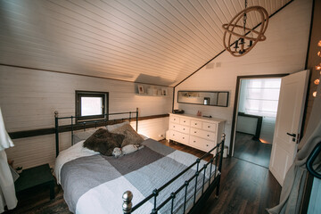 Modern scandi style bedroom interior. Nobody. A small cozy bedroom with a large soft bed