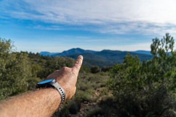 Closeup, male finger pointing to the mountains