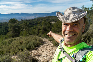 Smiling hiker taking a selfie pointing with fingers