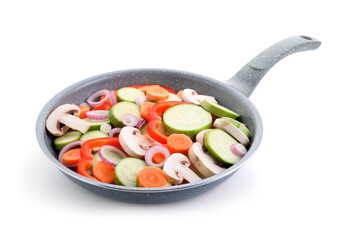 Frying pan with mix of fresh vegetables and mushrooms isolated on white
