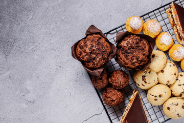 Table with various cookies, pound cake, cake slices, muffins and sweets.