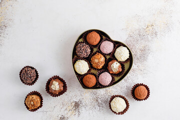 Homemade chocolate truffles with dark chocolate ganache covered with pink powder, waffle crumbles, gold flakes, coconut and nuts