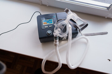 CPAP Machine for Sleep Apnea Treatment with Hose and Mask on a Table