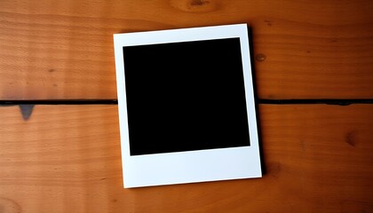 blank polaroid placed on wooden table